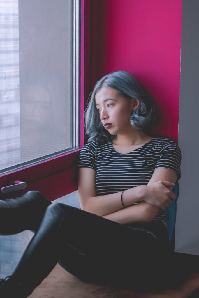 woman in black and white striped shirt while looking out at the window